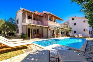 a villa with a swimming pool and a house at Villas Rab Palit in Rab