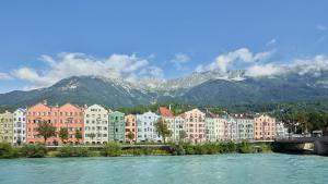 a city with buildings and a river and mountains at Hotel kontor in Hall in Tirol