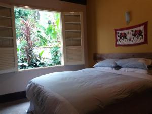 En eller flere senger på et rom på "Chalé Balines Oroboro" 1 - Casa com jardim de 150 m e cozinha completa em Macacos