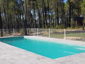 una piscina con acqua blu di fronte a una recinzione di Cabañas Rurales Los Barrancos a Villalba de la Sierra