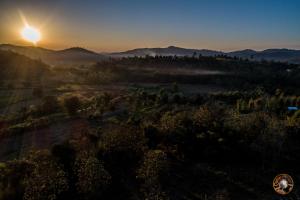 an aerial view of a valley with the sun setting at Khunyuam Resort in Ban Khun Yuam