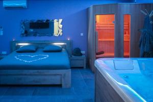a blue bedroom with a bed and a tub at Nuit vip spa sauna privatif in Le Rove