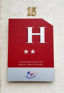 a sign on a wall with the h on it at Hôtel Neptune Place d'Italie in Paris