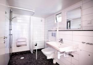 a white bathroom with a sink and a toilet at First Camp City-Stockholm in Stockholm