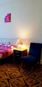 ブラックプールにあるHotel Avano - Pleasure Beachのベッドルーム1室(ベッド1台、青い椅子、ランプ付)