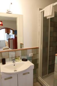 Casa Geo Sperlongaresort في سبرلونغا: حمام مع حوض ودش مع مرآة