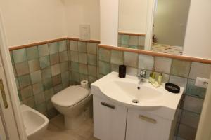 Casa Geo Sperlongaresort في سبرلونغا: حمام مع حوض أبيض ومرحاض