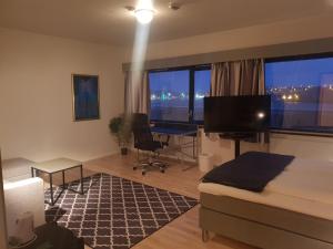 Schlafzimmer mit einem Bett, einem Schreibtisch und einem großen Fenster in der Unterkunft Vardø Hotel in Vardø
