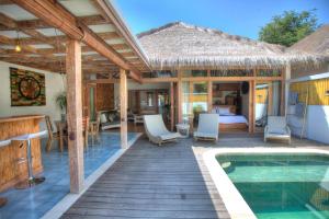 a villa with a swimming pool and a bedroom at Kempas Villa in Gili Air