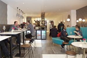 Eine Gruppe von Menschen sitzt an Tischen in einem Restaurant in der Unterkunft The Z Hotel Bath in Bath