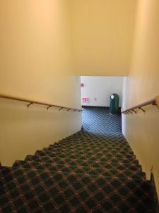 an empty room with stairs and a hallway with a trash can at Americas Best Value Inn & Suites-Spring Valley in Spring Valley