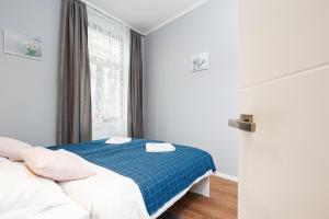 niewielka sypialnia z łóżkiem i oknem w obiekcie Apartments Kraków Borowickiej by Renters w Krakowie