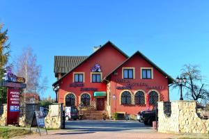 a large red building with a sign in front of it at Zajazd Zagłoba in Widoma