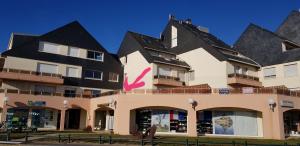 a large building with a pink tick on it at Appartement vue sur mer et port in Grandcamp-Maisy