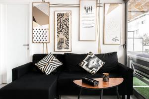 ein schwarzes Sofa im Wohnzimmer mit einem Tisch in der Unterkunft The Athenians Modern Apartments in Athen