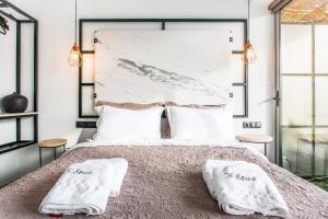 a bedroom with a large bed with two white towels at The Athenians Modern Apartments in Athens