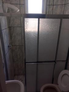 baño con ducha y aseo y ventana en Caeté, en Torres