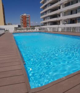 Una gran piscina azul frente a un edificio en Departamento Central Uno Norte Viña del Mar, en Viña del Mar
