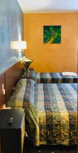 Hotel Parco Fiera في تورينو: غرفة في الفندق بها سرير وطاولة بها زهور