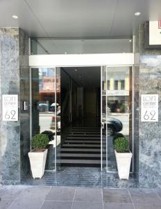 um hall de entrada de um edifício com dois vasos de plantas em Center Verdes Pássaros Loft em Porto Alegre