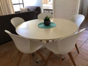 a white table and chairs with a plant on top at Apt 42 Riverview Holiday Apartments in Kalbarri