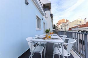 a balcony with a white table and chairs at Estrela Terrace by Homing in Lisbon