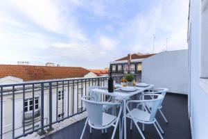 a balcony with a white table and chairs at Estrela Terrace by Homing in Lisbon