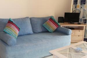 アルヴォルにあるVila Marachique Vl Alvorのリビングルーム(青いソファ、カラフルな枕2つ付)