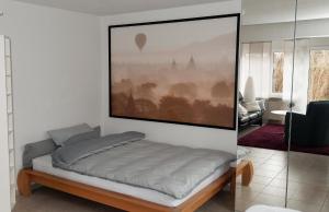 1 dormitorio con 1 cama con una foto en la pared en Nähe Spieleland en Vogt