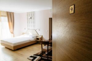 a bedroom with a bed and a desk with a chair at Spa&Hotel Studenac in Trebinje