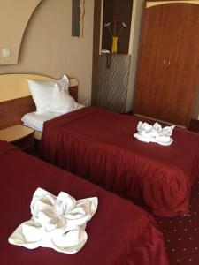 two beds in a hotel room with white towels on them at Hotel Kleyn in Constanţa