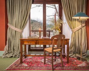 a wooden desk with a chair and a window at Country Club Hotel & Suites in Mikro Chorio