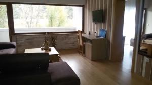 ein Wohnzimmer mit einem Sofa und einem großen Fenster in der Unterkunft Spa&Hotel Studenac in Trebinje