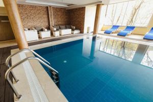 einen Pool in einem Hotelzimmer mit Stühlen in der Unterkunft Spa&Hotel Studenac in Trebinje