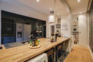 a kitchen with a wooden counter top and a sink at Le Leblois - 2 sdb Grande cuisine in Strasbourg