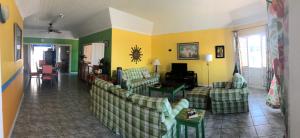 a living room with couches and a living room with yellow walls at Sol Mar Villa in Duncans