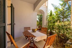 a wooden table and chairs on a patio at Villas Rab Palit in Rab