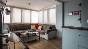 ein Wohnzimmer mit einem Sofa und einem Tisch in der Unterkunft Piraeus Apartment with Endless View in Piräus