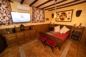 a bedroom with a bed and a flat screen tv at La Bodeguita de Alhama in Alhama de Aragón