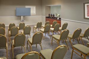 Sala de conferencias con sillas y pantalla de proyección en New Haven Village Suites en New Haven