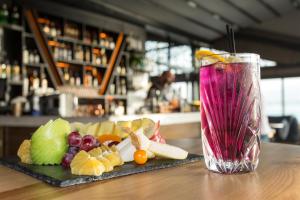 a drink sitting on a table with a plate of fruit at Wes Hotel in Kocaeli