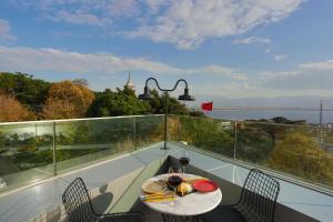 een tafel en stoelen op een balkon met uitzicht op het water bij Wes Hotel in Kocaeli