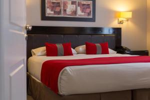 a bedroom with a large bed with red pillows at Alto Andino Hotel in Ushuaia