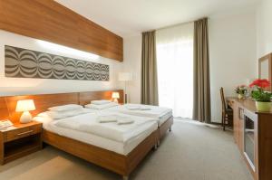 a bedroom with a large bed and a large window at Hotel Kelep in Tokaj