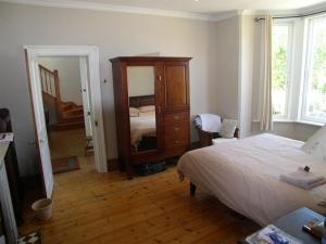a bedroom with a bed and a dresser and a mirror at Werner Guest Room in Cape Town