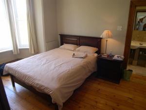 - une chambre avec un grand lit et une lampe sur une table dans l'établissement Werner Guest Room, au Cap 6 autres photos