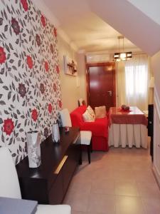 a living room with a red couch and a red bed at Casa cueva de la sombra in Setenil