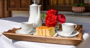 una bandeja con dos tazas y un pastel y rosas en Fretzato, en Elati