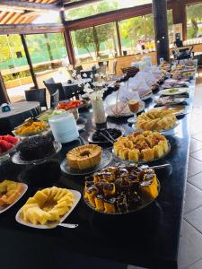 a long table filled with pies and desserts on plates at Nannai Beira Mar Porto de Galinhas 307 in Porto De Galinhas