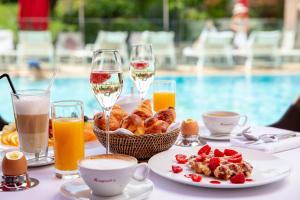 a table with breakfast food and glasses of champagne at Hôtel Barrière Le Majestic Cannes in Cannes